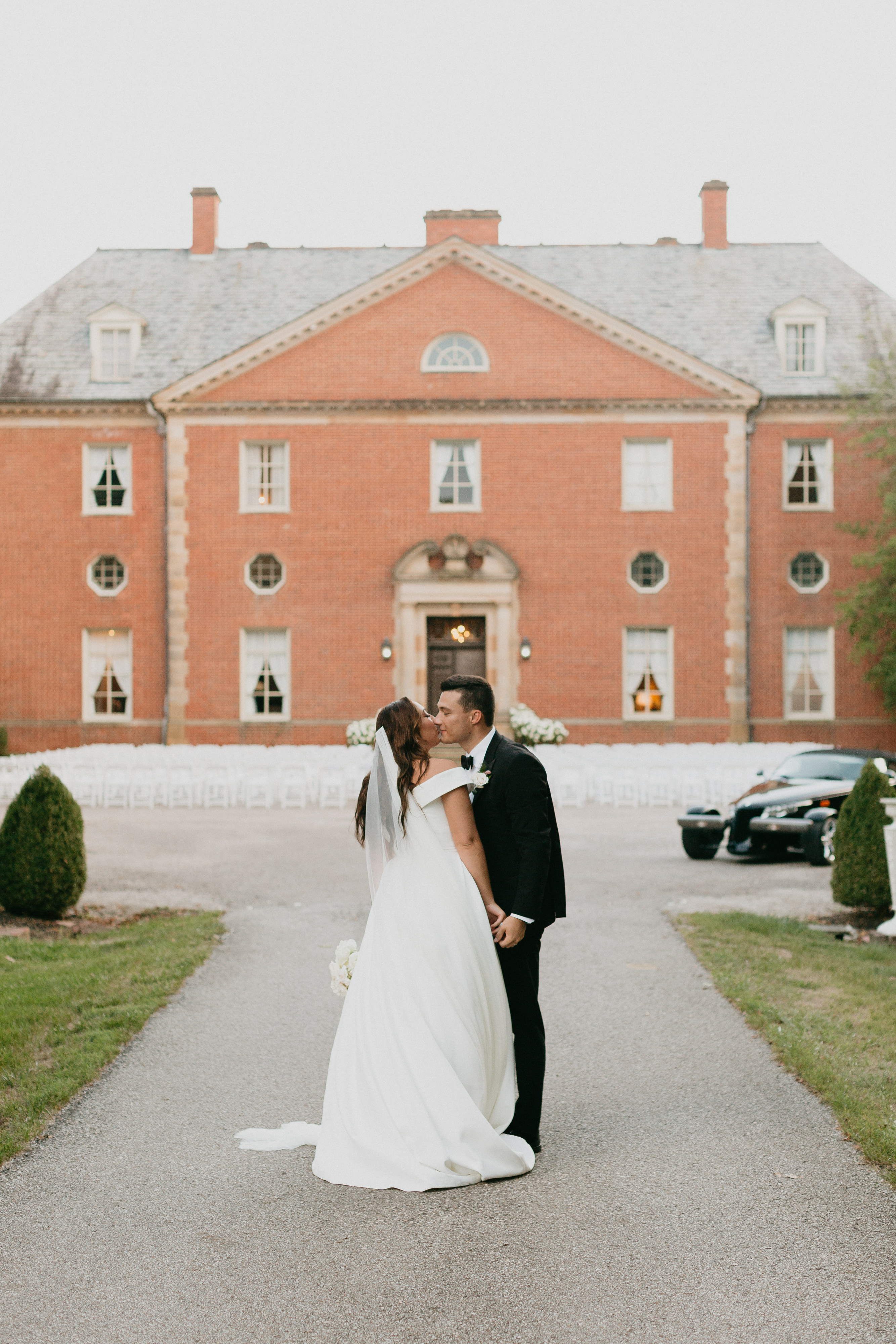 Bride and groom embrace with brick venue in the background | Cincinnati Wedding Planner